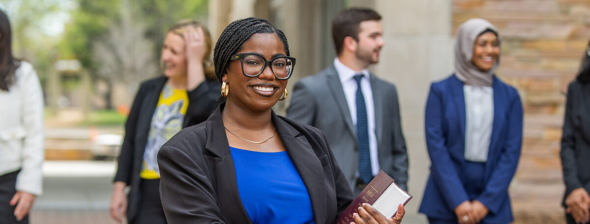 Photo of law student smiling holding a law book