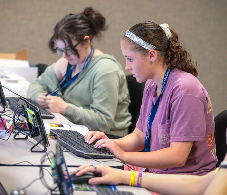 Students sitting and typing with a tablet